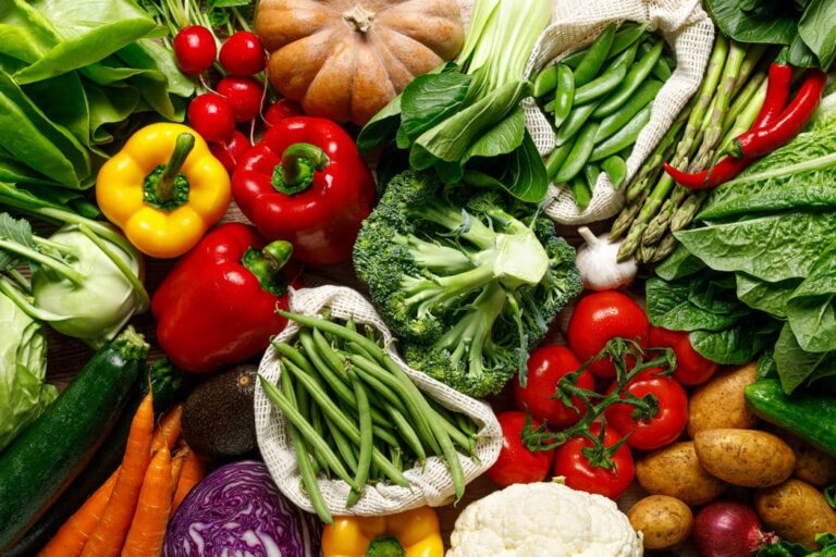 Eine bunte Vielfalt an frisch geerntetem Gemüse wie Zucchini, Tomaten, Paprika, Brokkoli und Karotten in einer dekorativen Anordnung
